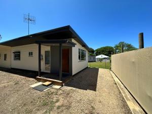 a small white building with a black roof at Luxury Holiday Unit 8min walk to Town Center with Boat Parking in Mallacoota