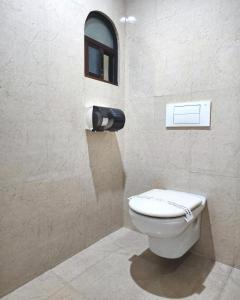 a bathroom with a white toilet and a window at Motel Atenas in Puebla