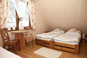 two twin beds in a room with a window at Alpejka - Domek Górski in Idzików