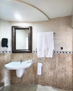 a bathroom with a sink and a mirror at Motel Atenas in Puebla