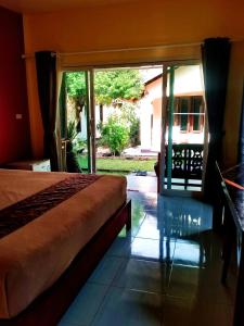 a bedroom with a bed and a large sliding glass door at Suwantana Lanta Houses in Ban Khlong Bang Chak +54 photos
