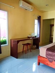 a bedroom with a desk and a bed and a window at Suwantana Lanta Houses in Ban Khlong Bang Chak