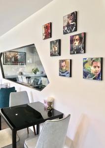 a dining room with a black table and pictures on the wall at Stardust Boutique Hotel in Hua Hin