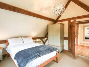 a bedroom with a bed and a chandelier at Keepers Cottage in Picklescott