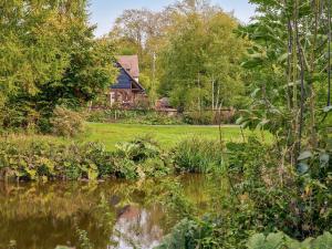 an old house with a pond in front of it at Keepers Cottage in Picklescott