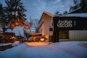 a snow covered yard in front of a building at Lodge Scole in Zaō Onsen