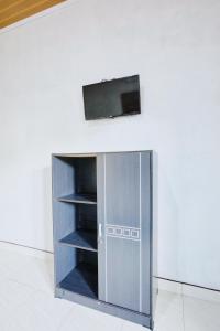 a metal cabinet with a tv on top of it at The Banana House in Nusa Penida