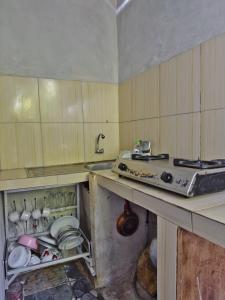 a kitchen with a sink and a stove in it at The Banana House in Nusa Penida