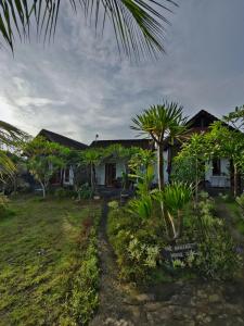 a house with a palm tree in front of it at The Banana House in Nusa Penida