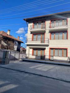 ein großes weißes Gebäude mit Balkon auf einer Straße in der Unterkunft Guest House Gogemi in Bansko