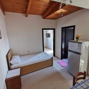 - une chambre avec un lit et un réfrigérateur dans l'établissement Ksamil Apartments, à Ksamil