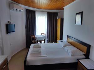 une chambre avec un lit, un bureau et une télévision dans l'établissement Ksamil Apartments, à Ksamil 37 autres photos