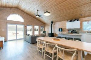 a kitchen and living room with a table and chairs at **WATERFRONT**BEAUTIFUL MODERN TOBERMORY COTTAGE in Miller Lake