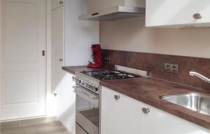 a kitchen with a stove top oven next to a sink at Stunning Home In Breskens With 2 Bedrooms And Wifi in Breskens