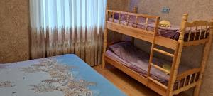 a bedroom with two bunk beds with purple sheets at Hasanovs Villa in Baku