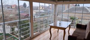a room with large windows with a table in front of it at Hasanovs Villa in Baku