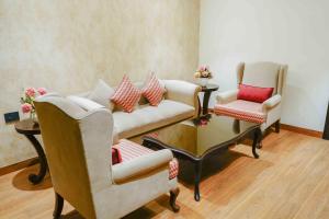 uma sala de estar com duas cadeiras e um sofá em The Grand Nirvana Hotel em Bareli