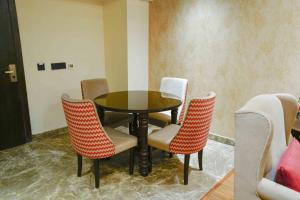 una mesa y sillas en una habitación en The Grand Nirvana Hotel, en Bareilly
