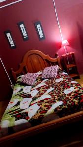 Un dormitorio con una cama con una manta. en Alquiler Temporario en Villa Cura Brochero