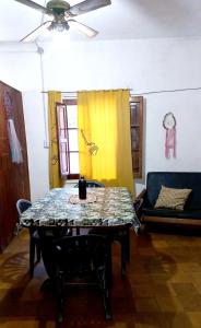 sala de estar con mesa y sofá en Alquiler Temporario en Villa Cura Brochero