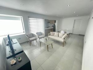 ein Wohnzimmer mit einem Sofa, Stühlen und einem Tisch in der Unterkunft Casa condominio costa del Sol a 1.4 km de Bahía Inglesa in Caldera