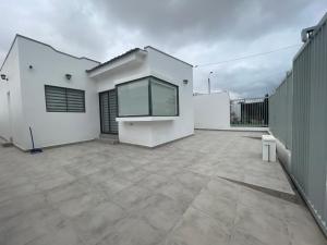 a large white house with a large patio at Casa condominio costa del Sol a 1.4 km de Bahía Inglesa in Caldera