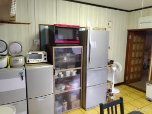 cocina con 2 neveras blancas y microondas en イマジンウエストオーシャン（ImagineWestOcean）, en Suo Oshima