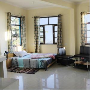 a bedroom with a bed and two windows at Yoga House in McLeod Ganj