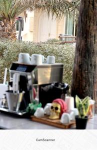 una cafetera sentada en una mesa junto a un árbol en Farm Lebanon, en Abu Dabi