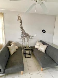 ein Wohnzimmer mit einer Giraffenstatue an der Wand in der Unterkunft San Lukas Guest Apartment in St Francis Bay