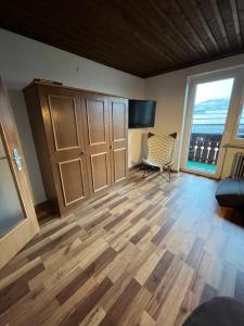 a living room with a wooden floor and a large window at Dachgeschoss-Apartment in Skilift-Nähe in Zell am See
