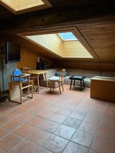 an attic room with a skylight and tables and chairs at Dachgeschoss-Apartment in Skilift-Nähe in Zell am See