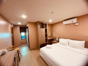 een hotelkamer met een bed en een bureau bij USABAI Riverside Boutique Hotel in Chanthaburi