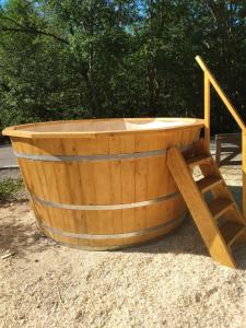 uma banheira de madeira ao lado de uma escada de madeira em Casa Catalin em Gura Humorului
