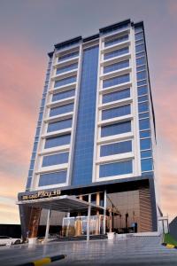 a tall building with a lot of windows at The Gate Hotel and Apartments in Dammam