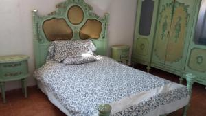 a bedroom with a bed with a blue comforter at El Fardous Flowerللرجال فقط in Alexandria
