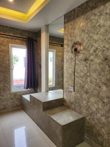 uma casa de banho com uma parede de pedra com uma flor na parede em Loft House Resort Pattaya em Praia de Jomtien