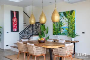 a dining room with a wooden table and chairs at Jungle Beach Villa in Nathon Bay