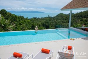 a swimming pool with a view of the ocean at Jungle Beach Villa in Nathon Bay
