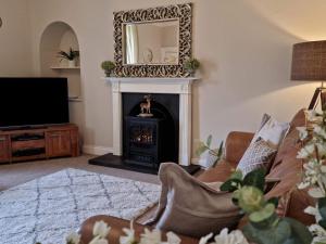 a living room with a fireplace and a mirror at Antfield House in Lochend