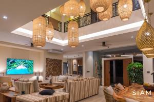 a lobby with couches and chairs and chandeliers at Jungle Beach Villa in Amphoe Koksamui