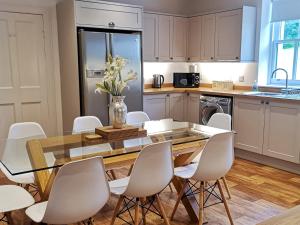 a kitchen with a dining room table and chairs at Antfield House in Lochend