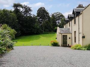 a house with a driveway in front of a green field at Antfield House in Lochend