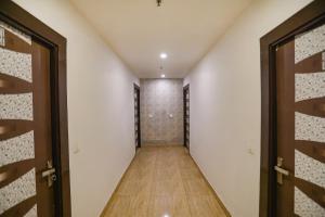 an empty hallway with doors and wood floors at FabHotel Joy Stick, Sector 11 Noida in Indirapuram