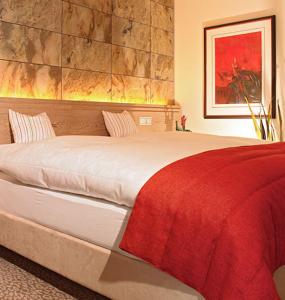 a bedroom with a large bed with a red blanket at Hof31 in Hilchenbach