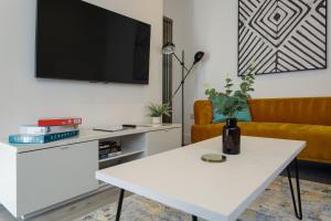 a living room with a white table and a tv at Heyshott Manor - Luxury 5 bedroom house in Portsmouth in Portsmouth