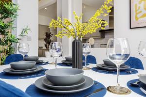 a table with blue and white plates and wine glasses at Heyshott Manor - Luxury 5 bedroom house in Portsmouth in Portsmouth
