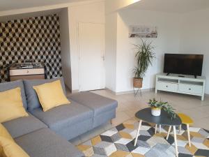 a living room with a couch and a tv at Gîte la crinière au vent in Étréaupont