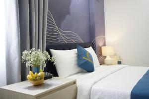 Schlafzimmer mit einem Bett mit blauen und weißen Kissen in der Unterkunft Moonlight Nha Trang Hotel in Nha Trang