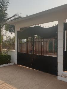 a black door with a gate in front of a building at PN Meublés FULL OPTION Odza Dispose d'une voiture et un chauffeur gratuitement de l,aéroport aux appartements pour des réservations minimum de 7 jours in Yaoundé